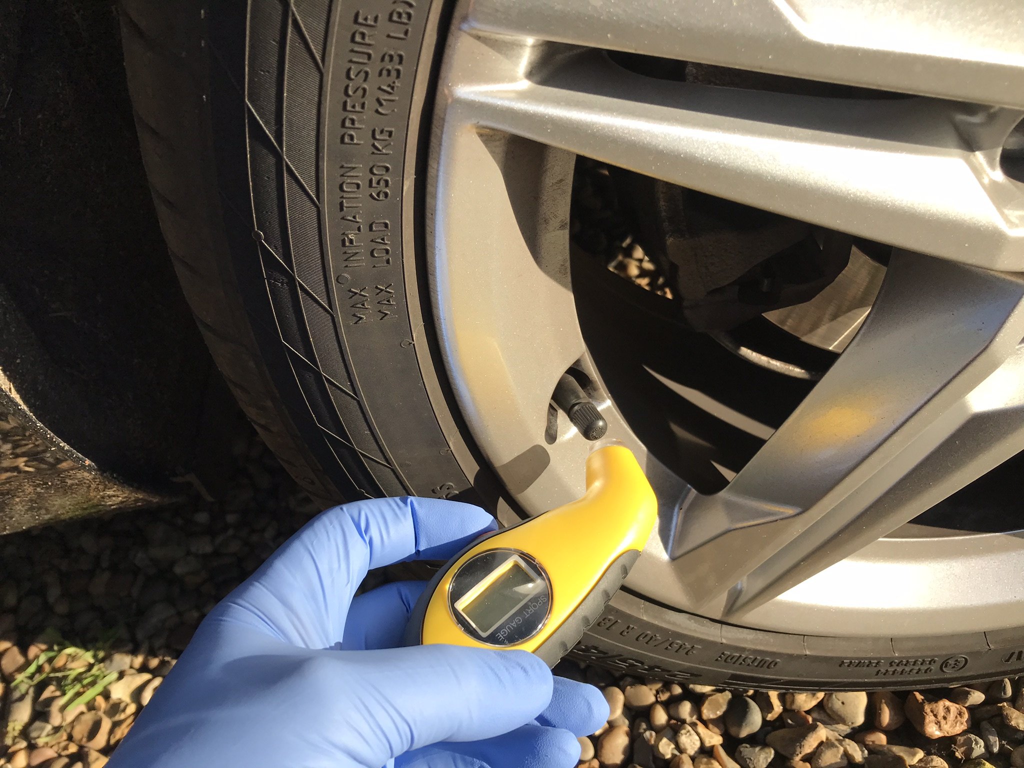 Digital tyre pressure gauge being used to check a tyre